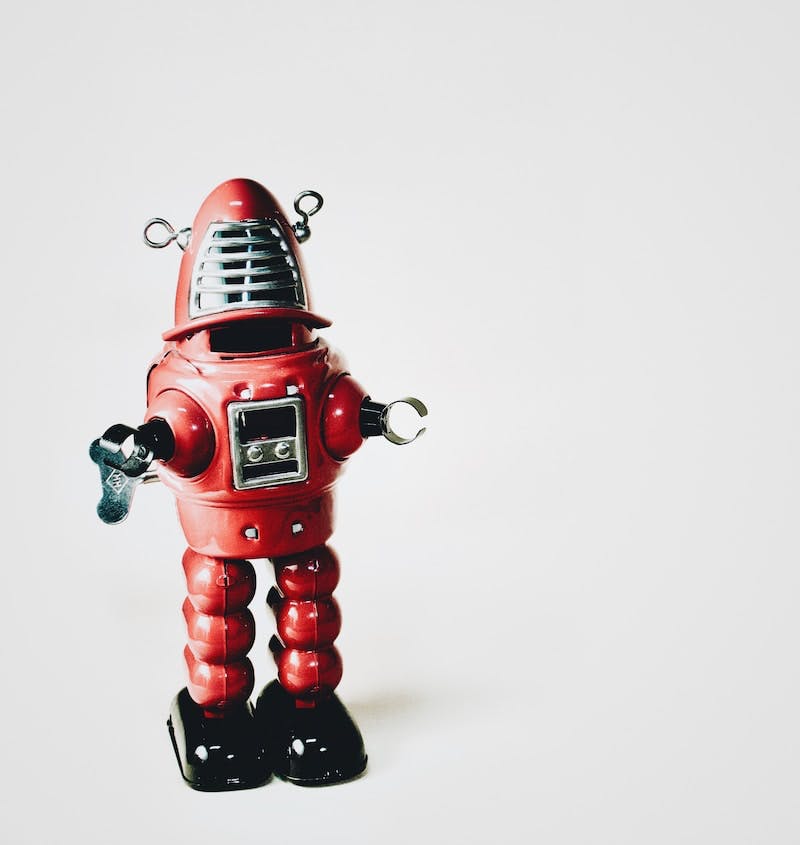 a red robot figurine with a microphone on it's head